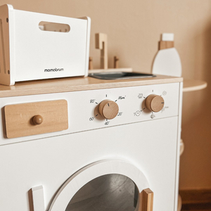 Puinen pyykinpesukone, jossa on silitysrauta, kori ja pesunestettä