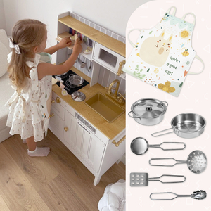 Puinen valkoinen keittiö tarvikkeineen ja esiliina