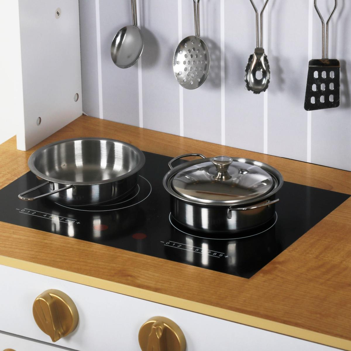 Puinen valkoinen keittiö tarvikkeineen ja esiliina