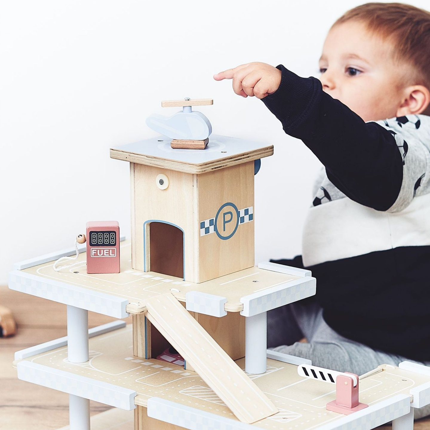 Puinen kolmikerroksinen parkkihalli, jossa on hissi - autotalli, jossa on autoja ja helikopteri