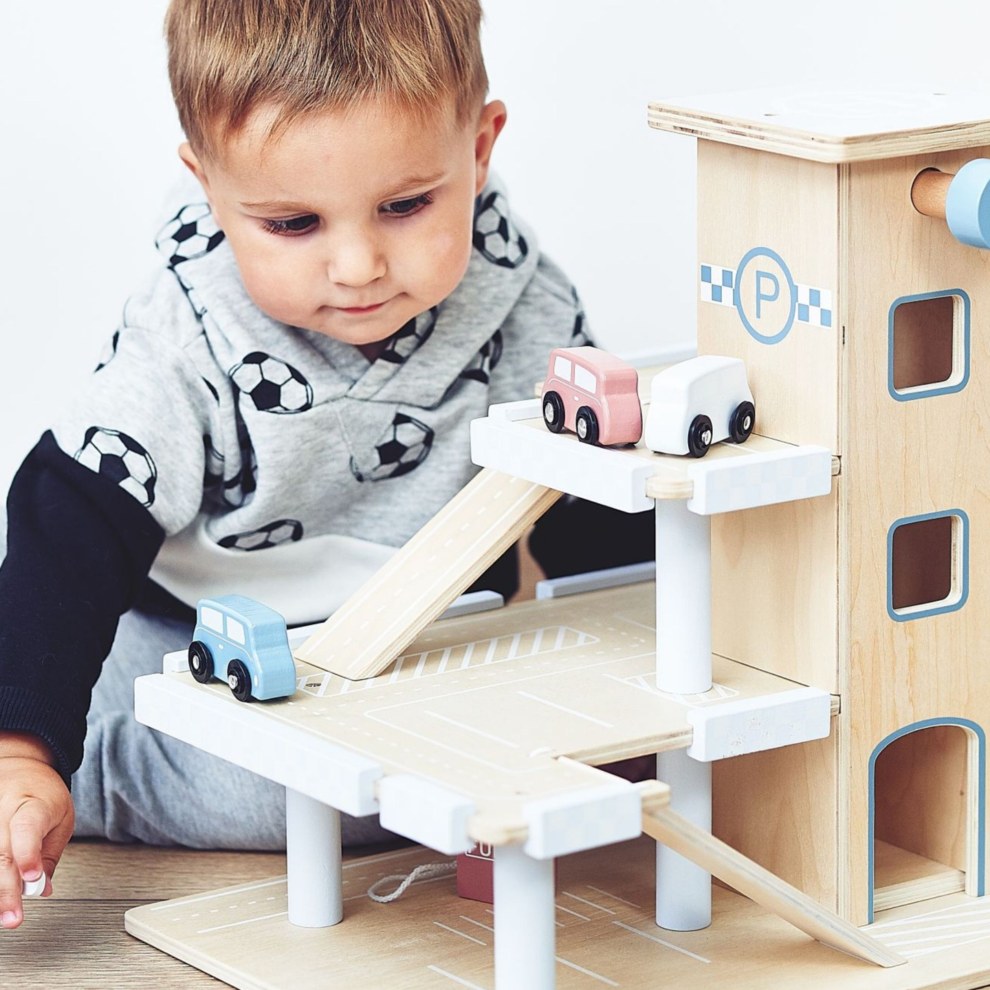 Puinen kolmikerroksinen parkkihalli, jossa on hissi - autotalli, jossa on autoja ja helikopteri