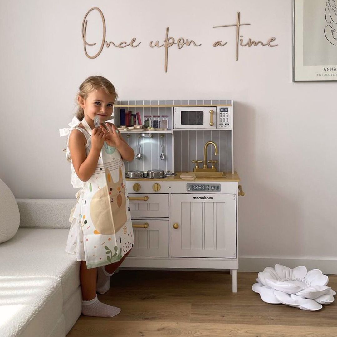 Puinen valkoinen keittiö tarvikkeineen ja esiliina